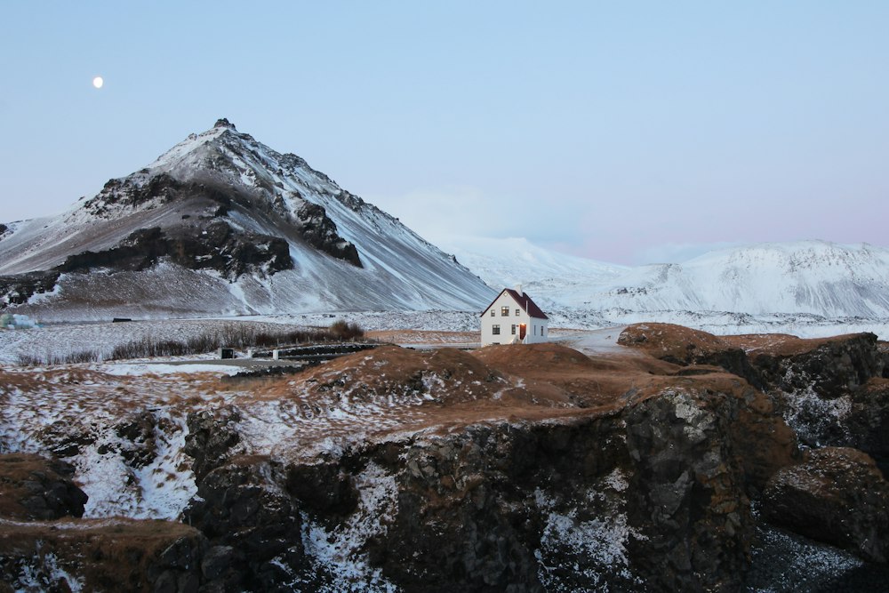 A lone house beneath a brown mountain near Arnarstapi