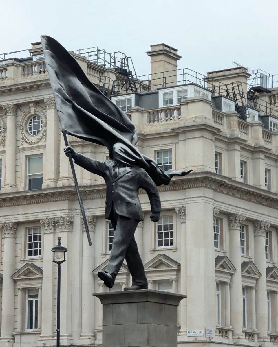Banksy's statue holding a flag in Waterloo Place, London